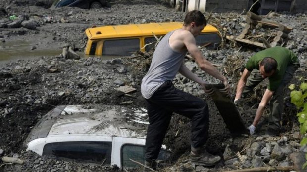The clean up begins ... Residents try to excavate a car trapped in the mud caused by a landslide at the village of Topcic Polje,  Bosnia-Herzegovina.