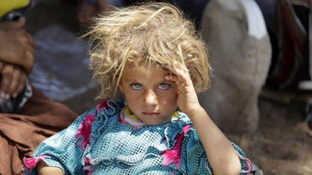 A Yazidi child rests at the Iraqi-Syrian border.