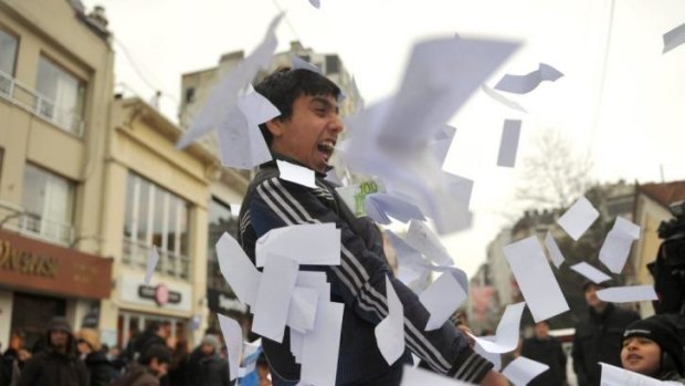 Children play with fake money after a protest against corruption in Istanbul, after leaked voice recordings emerged which allegedly feature Prime Minister Erdogan instructing his son to hide vast amounts of cash.