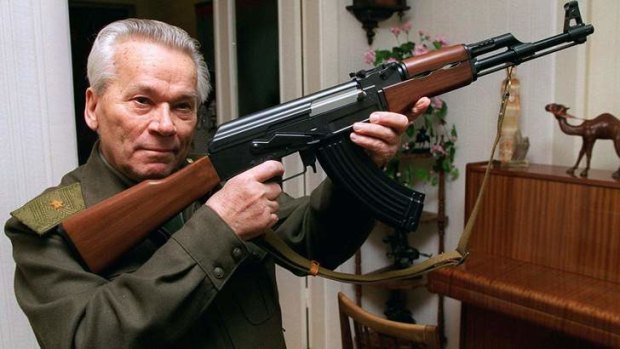Mikhail Kalashnikov shows a model of his world-famous AK-47 assault rifle in 1997.