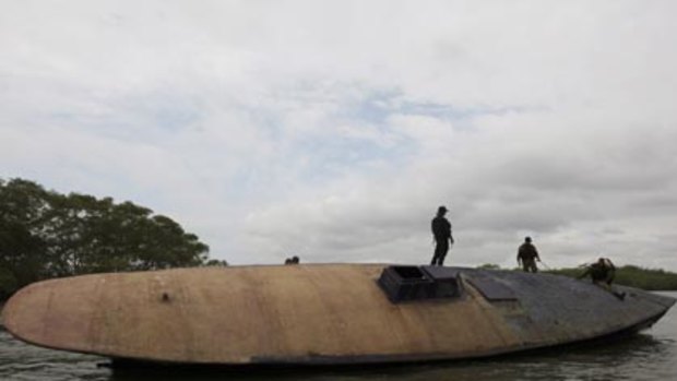 Columbian Navy officers guard a cocaine submarine.