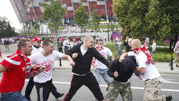 Punch-up ... fans scrap outside the National Stadium in Warsaw.