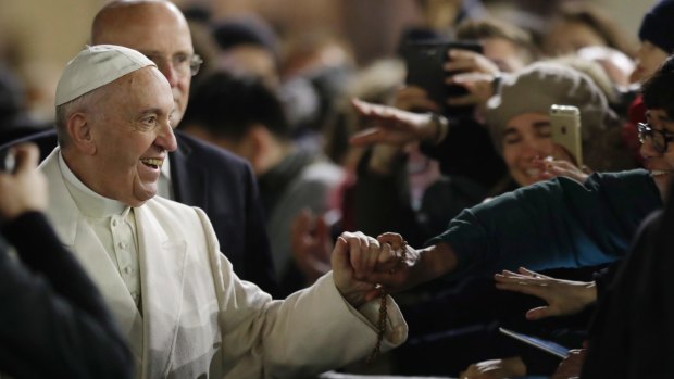 Pope Francis holds hands with faithful after celebrating a new year's eve vespers Mass in St. Peter's Basilica at the Vatican, Saturday, Dec. 31, 2016. (AP Photo/Andrew Medichini)