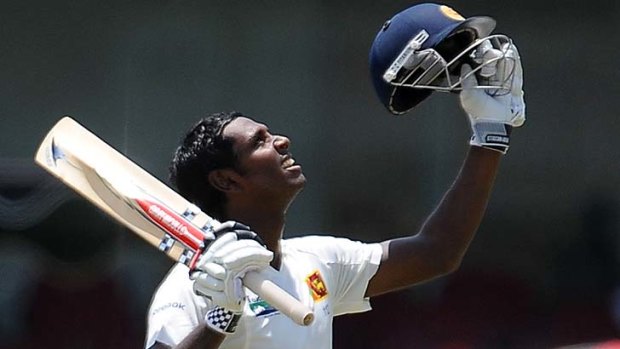 Sri Lankan batsman Angelo Mathews raises his bat after scoring a century during the third Test match against in Colombo in September 2011.