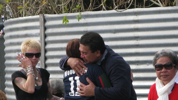Jeremiah Lale embracing one mourner at the scene of the fire on Thursday.