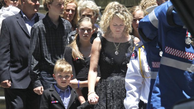 Sad farewell: Michael Wilson's wife Kelly and children with mourners at his funeral.
