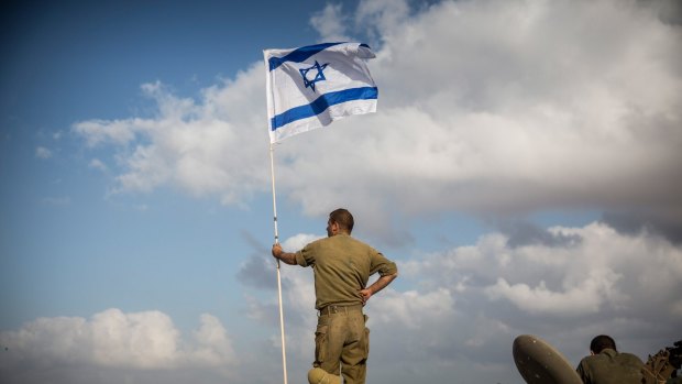 An Israeli soldier stands on top of an armoured personnel carrier near the Israel-Gaza Strip border during Operation Protective Edge in July 2014.