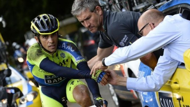 Spain's Alberto Contador gets assistance as he rides after a fall during the 161.50-km tenth stage.