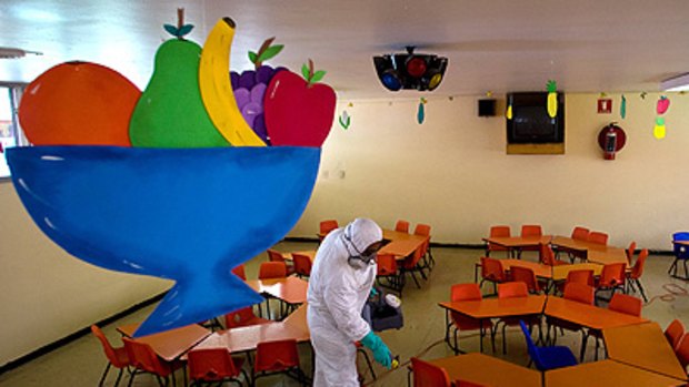 Precautions ... a cleaner disinfects a nursery school in Mexico City before children are due back in classes.