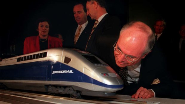 Former prime minister John Howard takes a close look at a "Speedrail'' model in 1998.