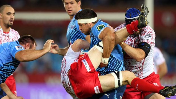Pierre Spies of the Bulls updends a Queensland player in  his team's  steamrolling of the Super Rugby premiers.