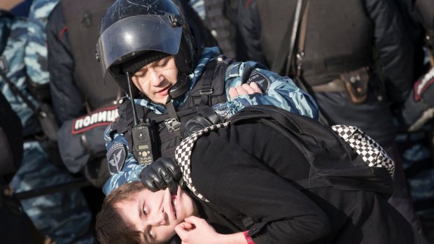 Police detain a man in Moscow as protests sweep Russia.