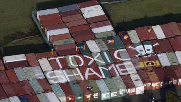 Greenpeace environmental activists climb on to containers and use paint to protest at the Orica site at Port Botany.
