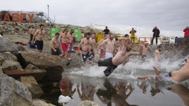 Protected only by board shorts, the Casey crew take the plunge into freezing water yesterday.