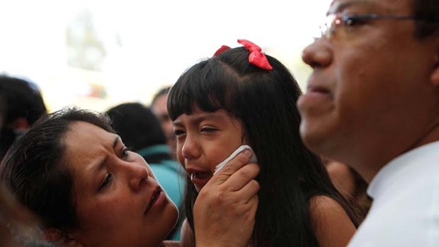 Reunited ... Margarita Almaraz comforts her daughter Ashley, as her father, Alfonso Mejia, looks on at the airport in Mexico City.