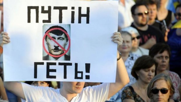Protest: A man holds a placard reading "Putin get out!" during a rally in the southern Ukrainian city of Mariupol.