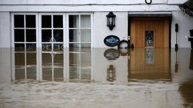 The front door of a house stands submerged by floodwater in Yalding, England.