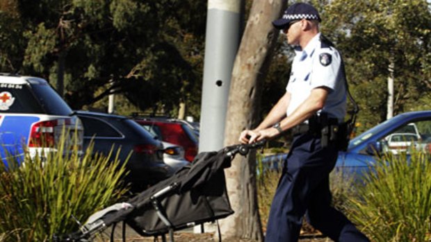 A police officer wheels the toddler's pram.