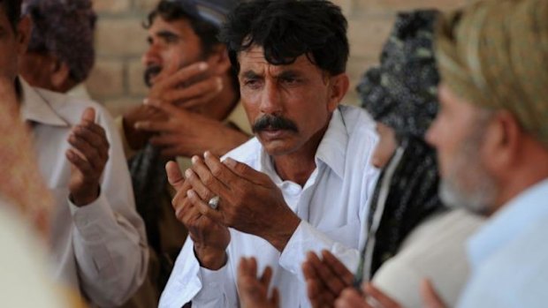 Strangled first wife ... Mohammad Iqbal prays alongside relatives for his late wife Farzana Parveen, who was stoned to death outside court.