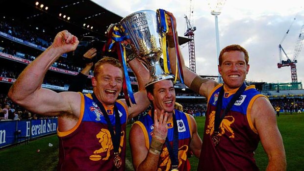 Ex-Brisbane coach Michael Voss, Collingwood assistant coach Craig McRae and new Lions boss Justin Leppitsch celebrate winning their third LIons premiership in 2003.