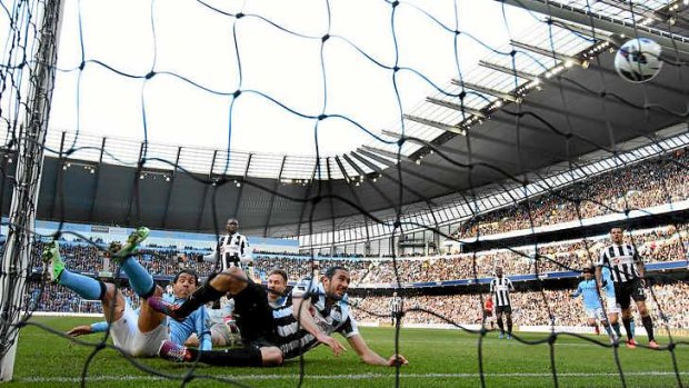 Carlos Tevez of Manchester City scores the opening goal against Newcastle.