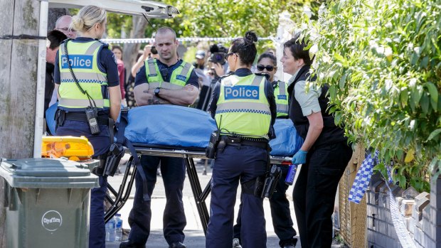 Coroners remove a body from one of the squatters' houses on Bendigo St, Collingwood.