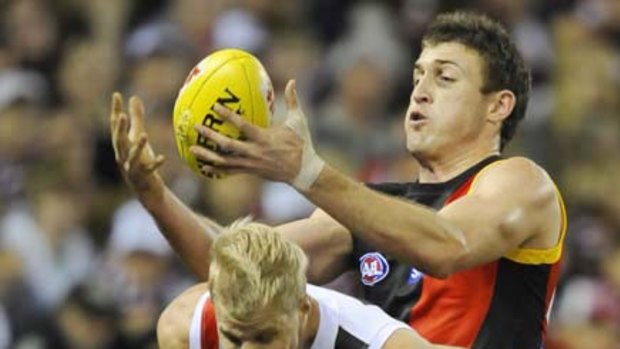 Essendon's Cale Hooker snatches the ball from Nick Riewoldt last night.