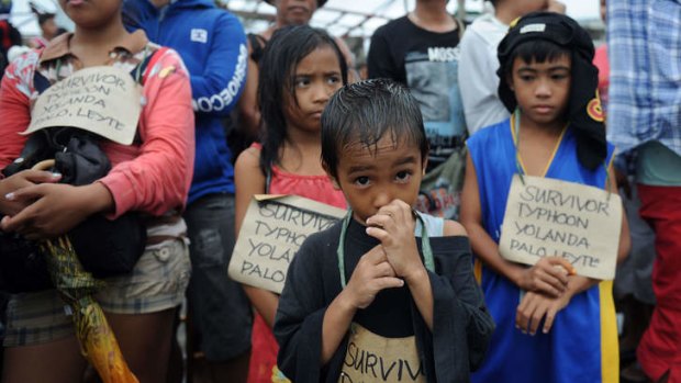 Separated from loved ones: Children with name tags wait at Tacloban airport.