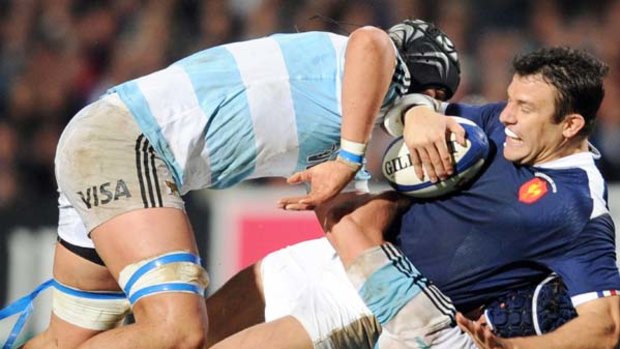 France's flyhalf Damien Traille is tackled by Argentina's lock Patricio Albacete.