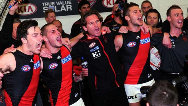 Essendon players and coach James Hird belt out the team song in the rooms after the come-from-behind win over Carlton.