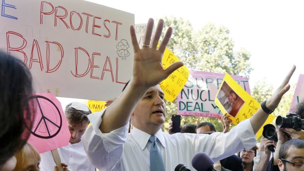 US Republican presidential candidate Senator Ted Cruz gestures as he engages in a  debate on the Iran nuclear deal with Code Pink peace activism group co-founder Medea Benjamin (left with small peace sign) across from the White House.