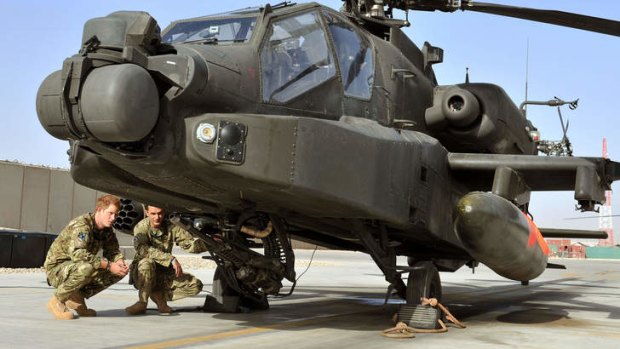 Prince Harry examines the 30mm cannon of an Apache helicopter in Afghanistan, where he is serving over Christmas.