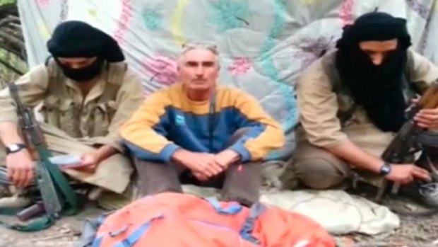 Beheaded by jihadists: A man who identified himself as French tourist Herve Gourdel sits between two masked gunmen in this still taken from a video.
