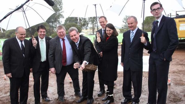 Premier Barry O'Farrell, accompanied by Transport Minister Gladys Berejiklian, turns a sod to mark the contract signing.