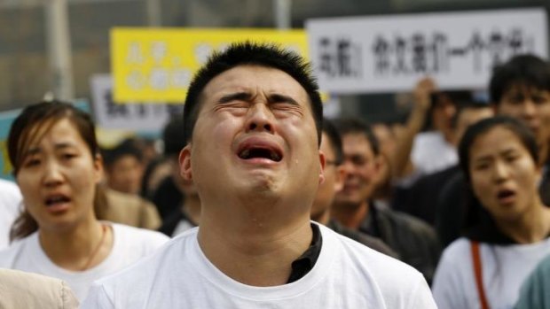 Grief and frustration ... A family member of a passenger on board Malaysia Airlines MH370 cries as he shouts slogans during a protest in front of the Malaysian embassy in Beijing.