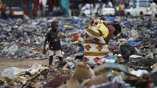A woman and child search through piles of refuse after violence left hundreds of thousands of people homeless.