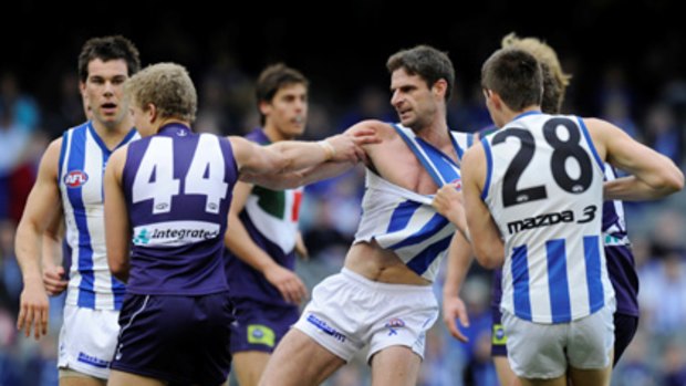 Heave ho .... North Melbourne's Brady Rawlings gets physical with Fremantle opponent Jesse Crichton.