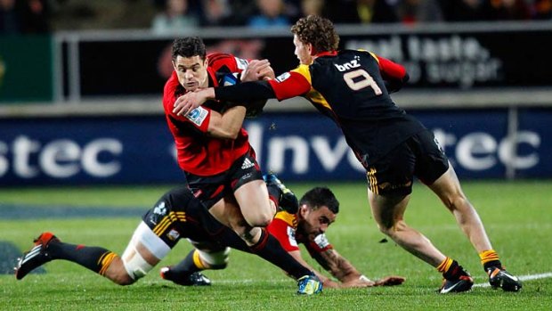 Daniel Carter of the Crusaders is tackled by Liam Messam and Tawera Kerr-Barlow of the Chiefs.