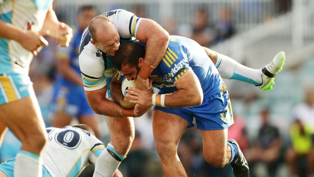 Hard yards: Eels prop Tim Mannah is tackled by Titans forward Matt White.