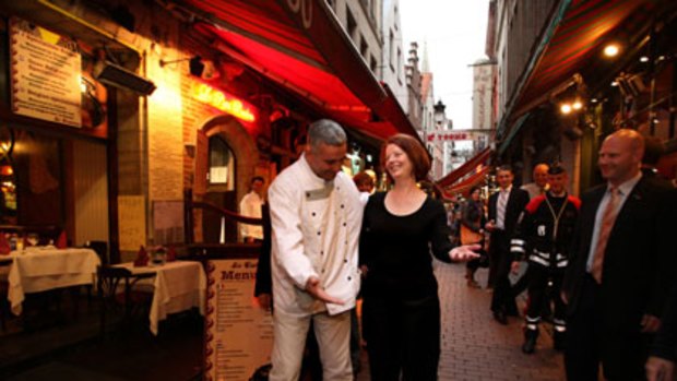 Off duty ... a local waiter has a friendly chat with Julia Gillard during her stroll around Brussel’s historic centre.