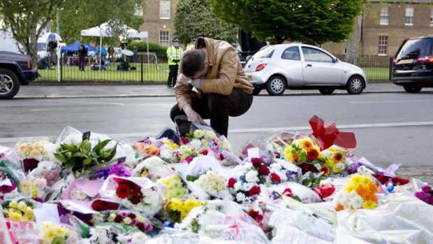 Shock: A man pays his respects as he looks at floral tributes outside Woolwich Barracks in London, where soldier Lee Rigby was brutally killed.
