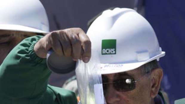Alejandro Pino, of the Chilean Security Association, ACHS,  puts some food into a tube to be sent to trapped miners.