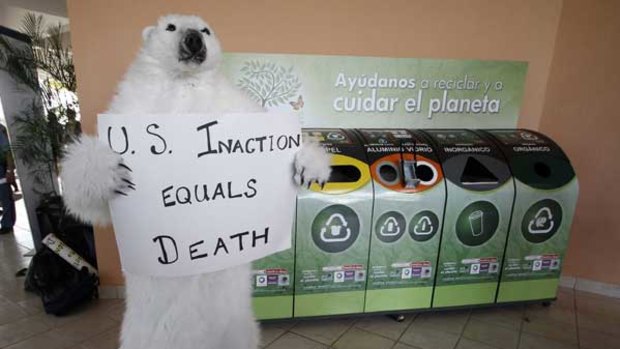 An activist in a bear costume pressures the US at Cancun.