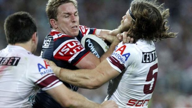 Roosters forward Mitchell Aubusson palms off Manly winger David Williams in the 2013 grand final.