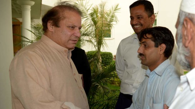 Needs coalition partners: Nawaz Sharif (left) meets party supporters at his residence in Lahore on Sunday.