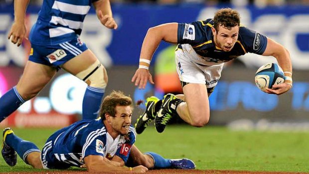 Robbie Coleman of the Brumbies skips over the tackle by Nick Groom of the Stormers.