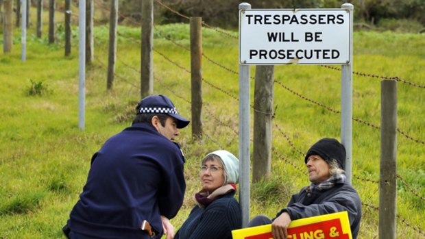 Protesters chain themselves to a sign just inside the desalination plant property at Wonthaggi.