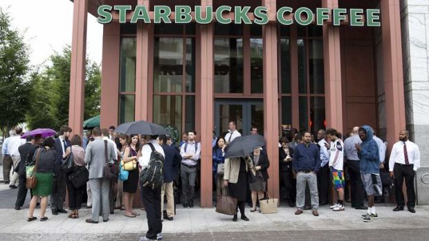 People stand outside a Starbucks Coffee shop that has been closed as police respond to a shooting at the Washington Navy Yard in Washington on Monday.