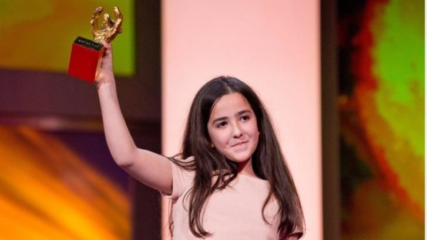 Hana Saedi, the niece of Iranian director Jafar Panahi, collects his Golden Bear, awarded for <i>Taxi</i>, at the Berlin Film Festival.