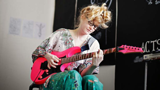 Heavy harmony: Nell plays guitar in her studio.